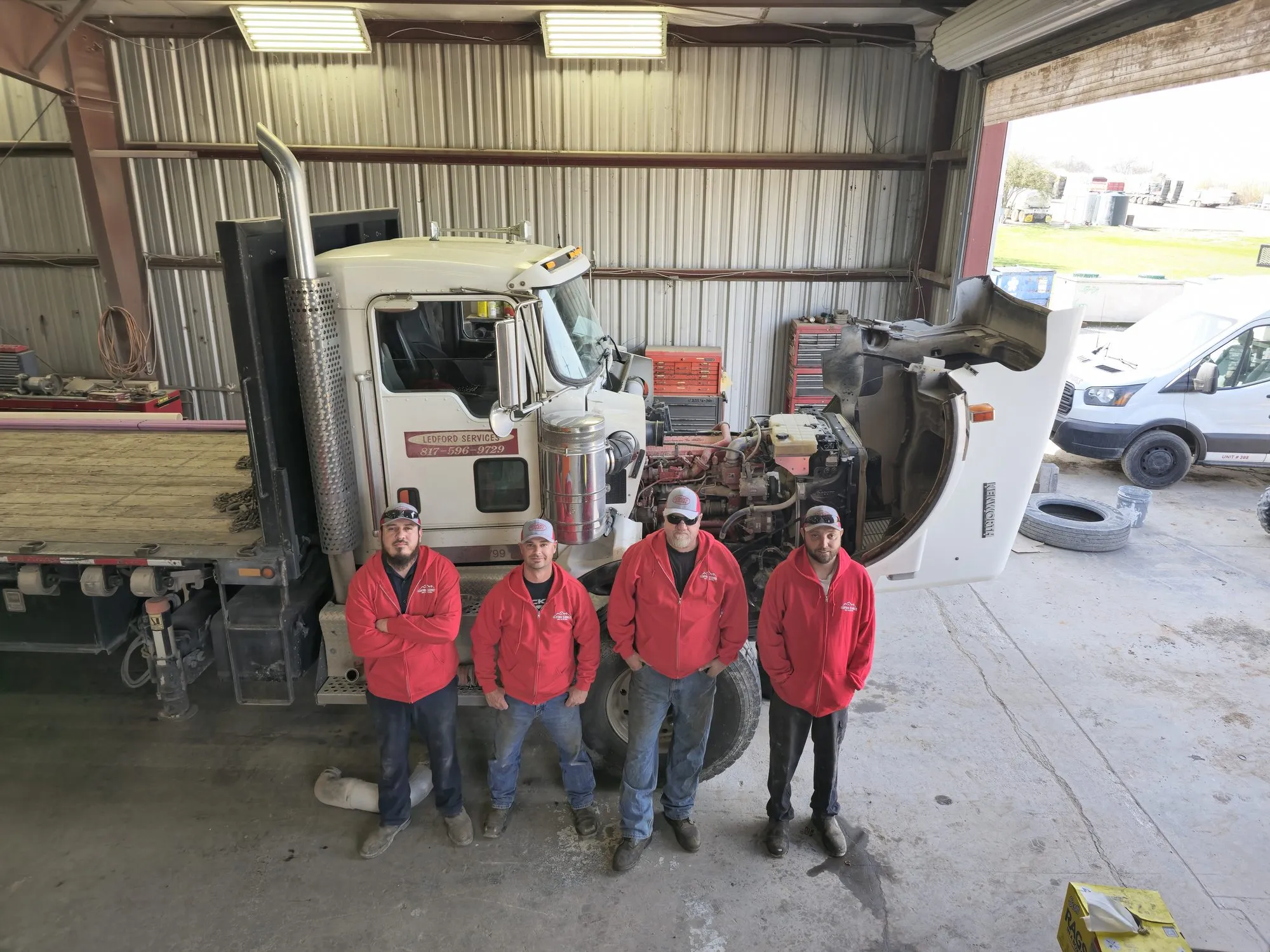 Ledford Services technicians in front of a septic pump truck in the shop