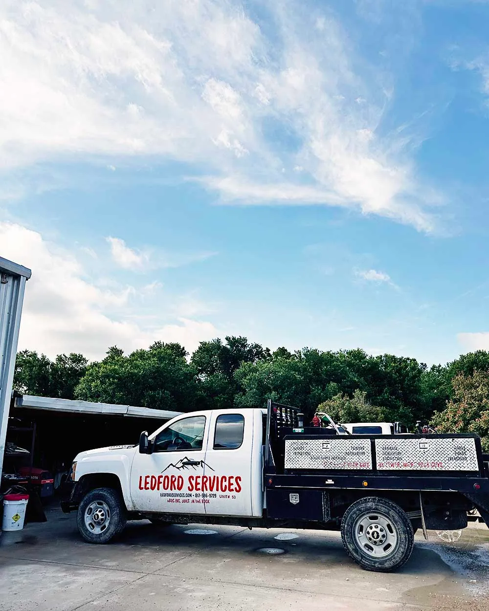 Ledford Services branded flatbed work truck at the shop