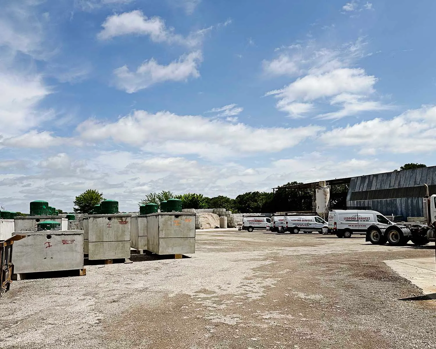 Ledford Services yard with precast septic tanks and branded service vans
